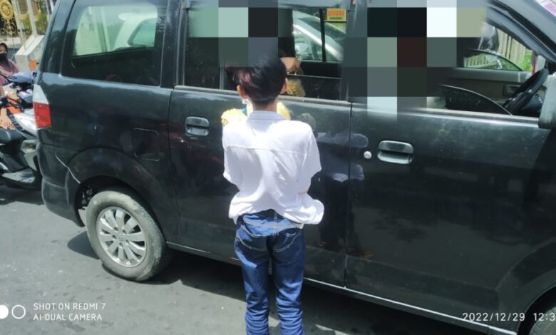 Salah seorang anak dibawah umur menawarkan dagangannya ke pengguna jalan disalah satu traffic light di Lombok Tengah.